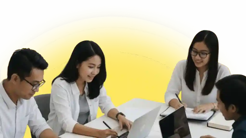 Team collaboration at a table with laptops and notebooks