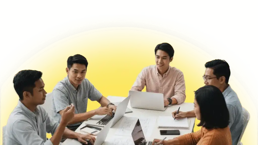 Team collaborating on content marketing strategy at a meeting table with laptops.